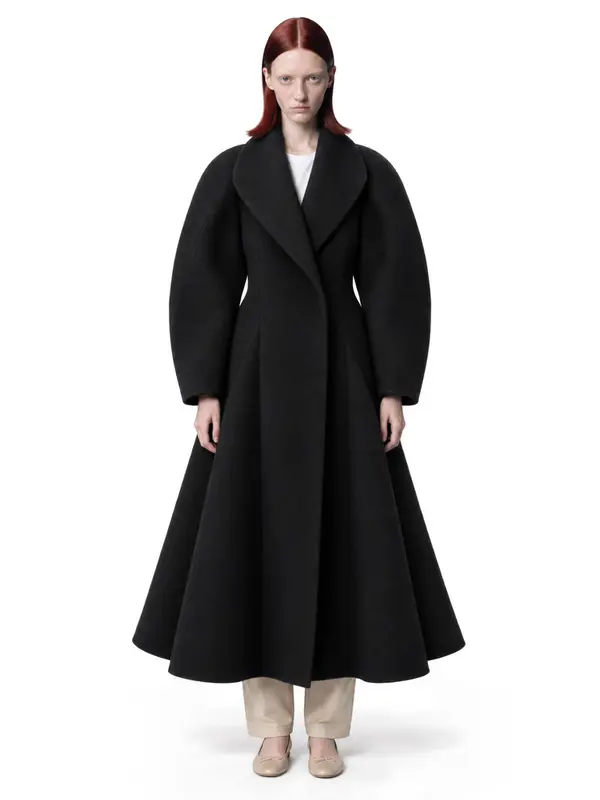 Black flared coat on an AI model, white wall, front