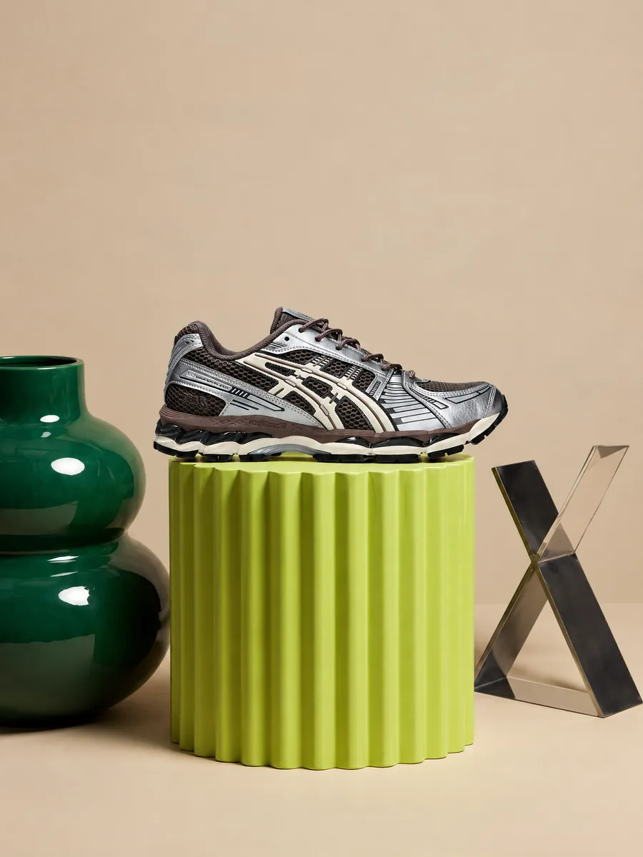 ASICS sneakers on a lime plinth, product still